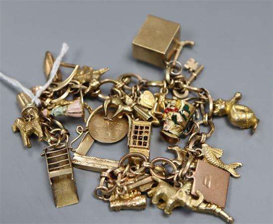 A yellow metal charm bracelet, hung with twenty seven assorted charms